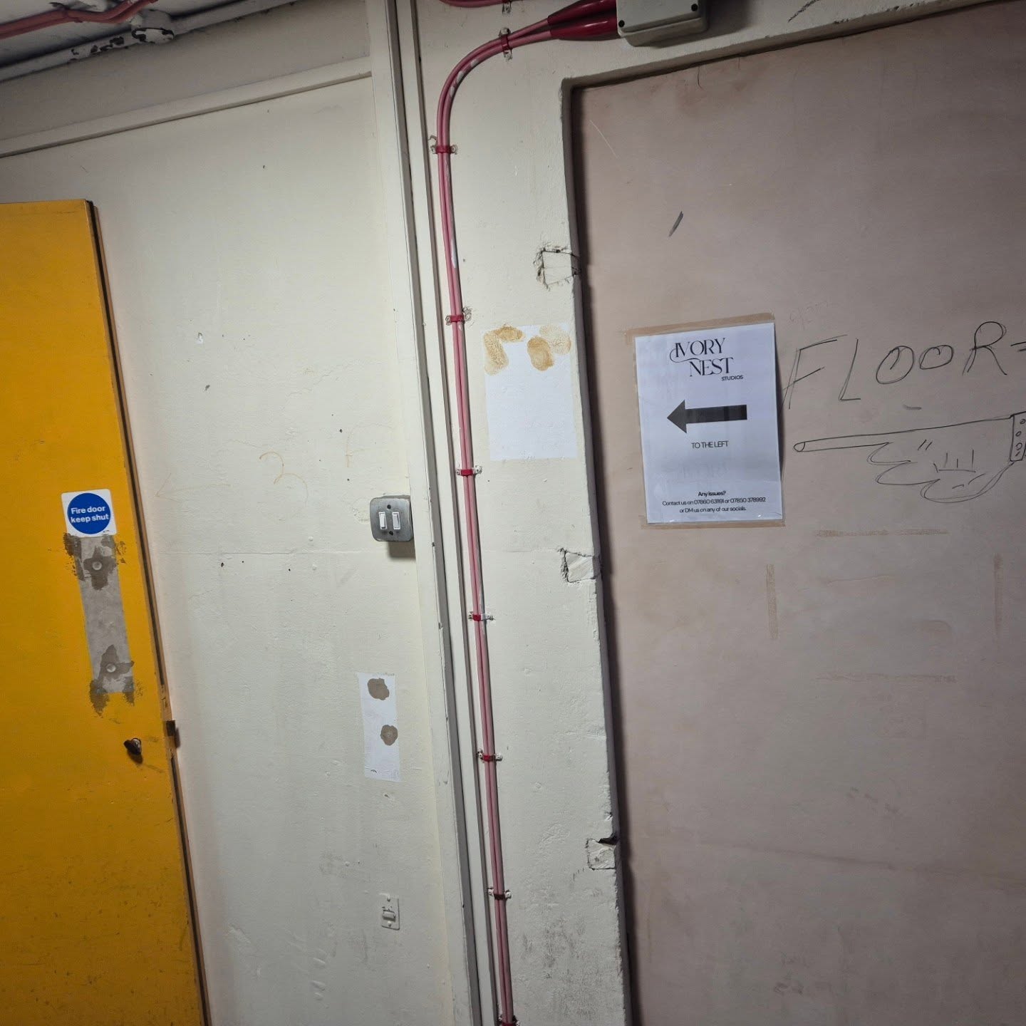 Corridor on the third floor with the Ivory Nest Studios sign pointing left
