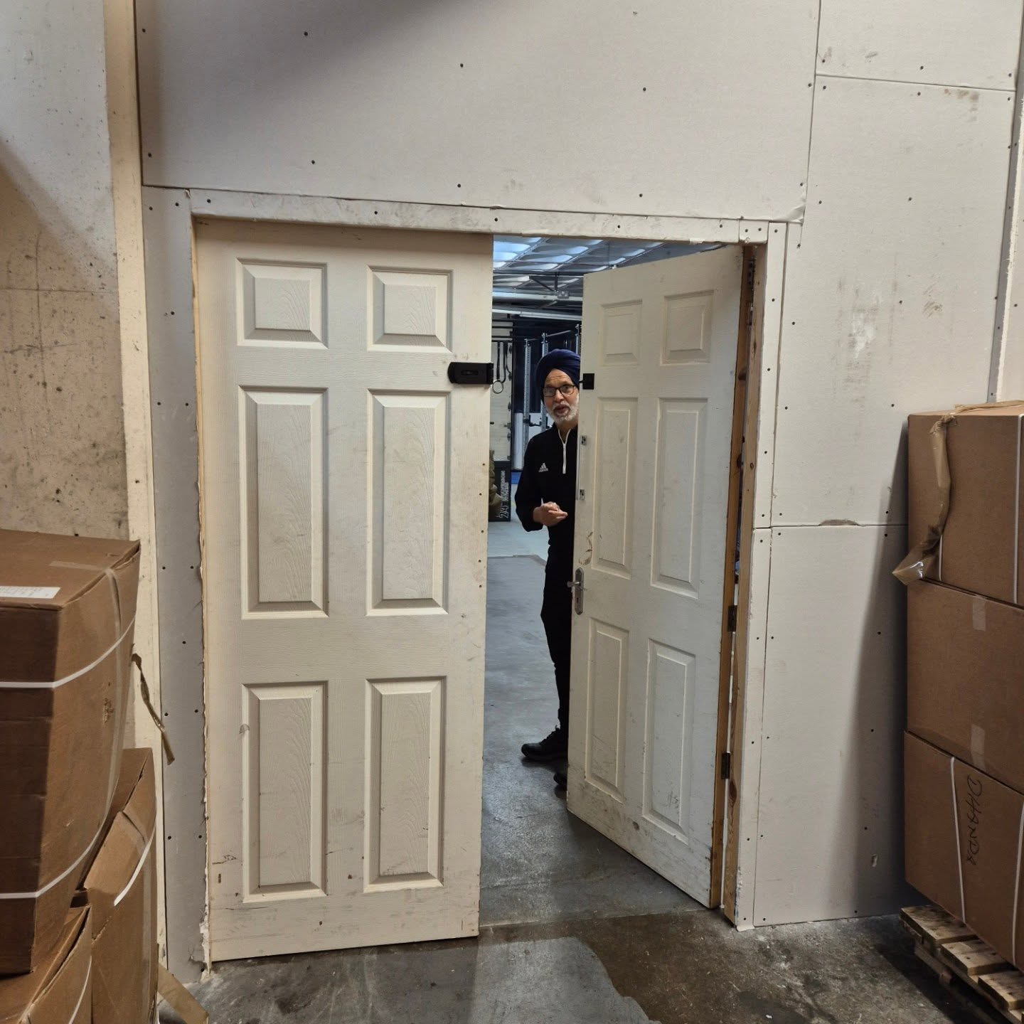 Double white doors opening into the wrestling training room